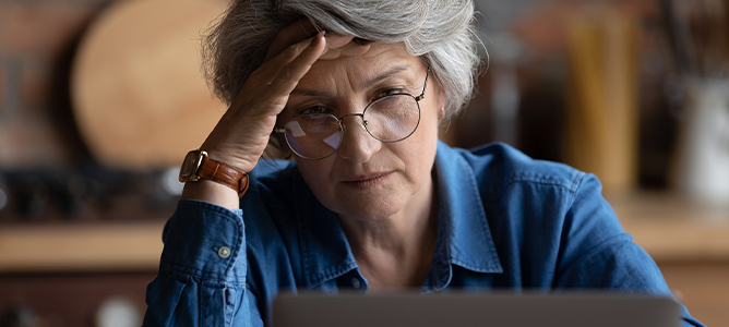 Worried senior woman looking at computer