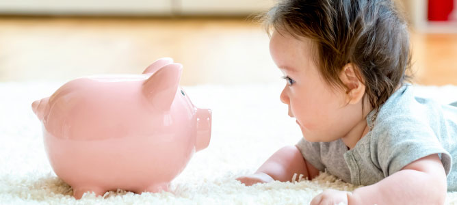 Baby on tummy looking at piggy bank
