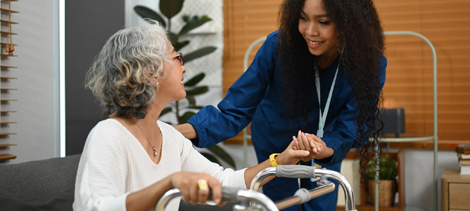 Female healthcare professional assisting senior woman