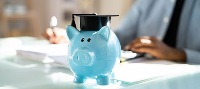 Blue piggy bank wearing graduation cap