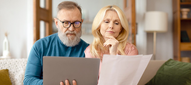 Concerned Couple Reviewing Paperwork